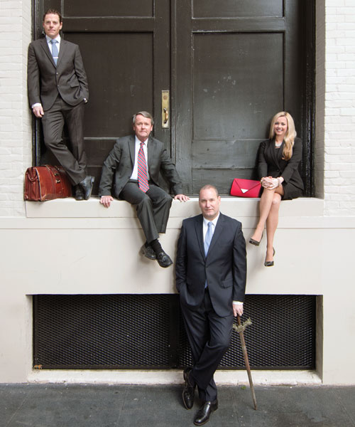 Photo of firm's attorneys in front of large doors